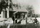 Syvälahden eli Aleksis Kiven kuolinmökin pihamaalla 1910-luvun alkupuolella. Albert ja Wilhelmiina Stenvall seisovat taka-alallla, etualalla Krapin tilan väkeä.